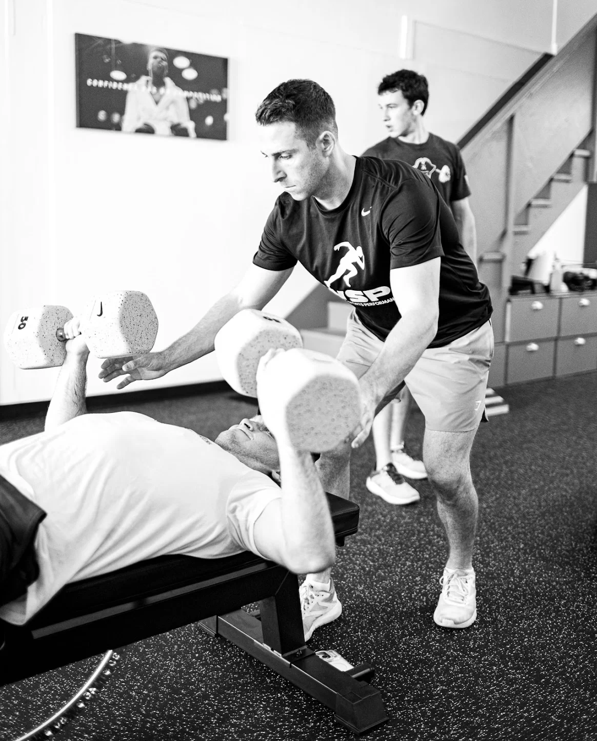 Coach spotting an athlete during a dumbbell bench press at WSP