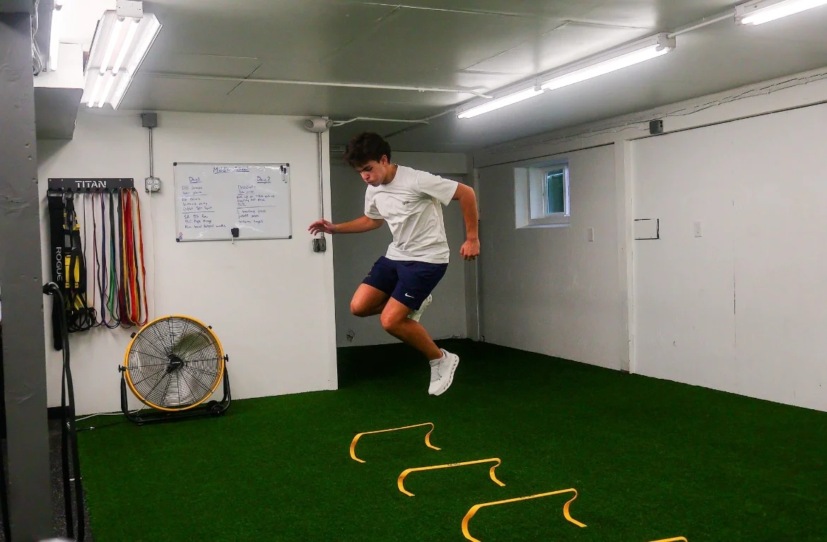 Athlete clearing yellow mini hurdles on the WSP turf